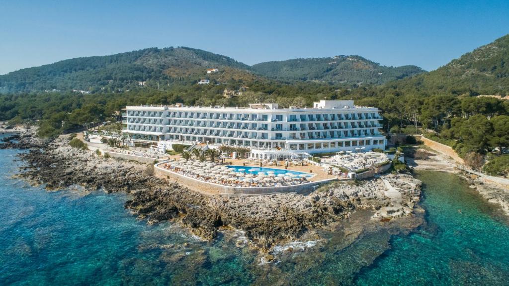 un hôtel sur une falaise à côté de l'eau dans l'établissement Grupotel Aguait Resort & Spa - Adults Only, à Cala Ratjada