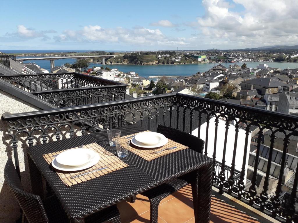 una mesa en un balcón con vistas a la ciudad en Atico céntrico con piscina comunitaria, en Ribadeo