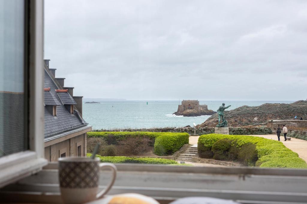 uma janela com vista para o oceano e uma estátua em Le Plongeoir by Cocoonr em Saint Malo