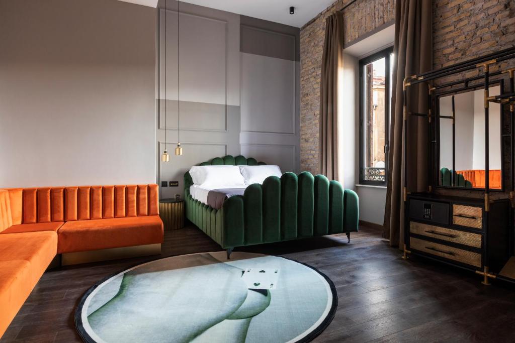 a bedroom with a bed and a couch and a table at Chapter Roma in Rome