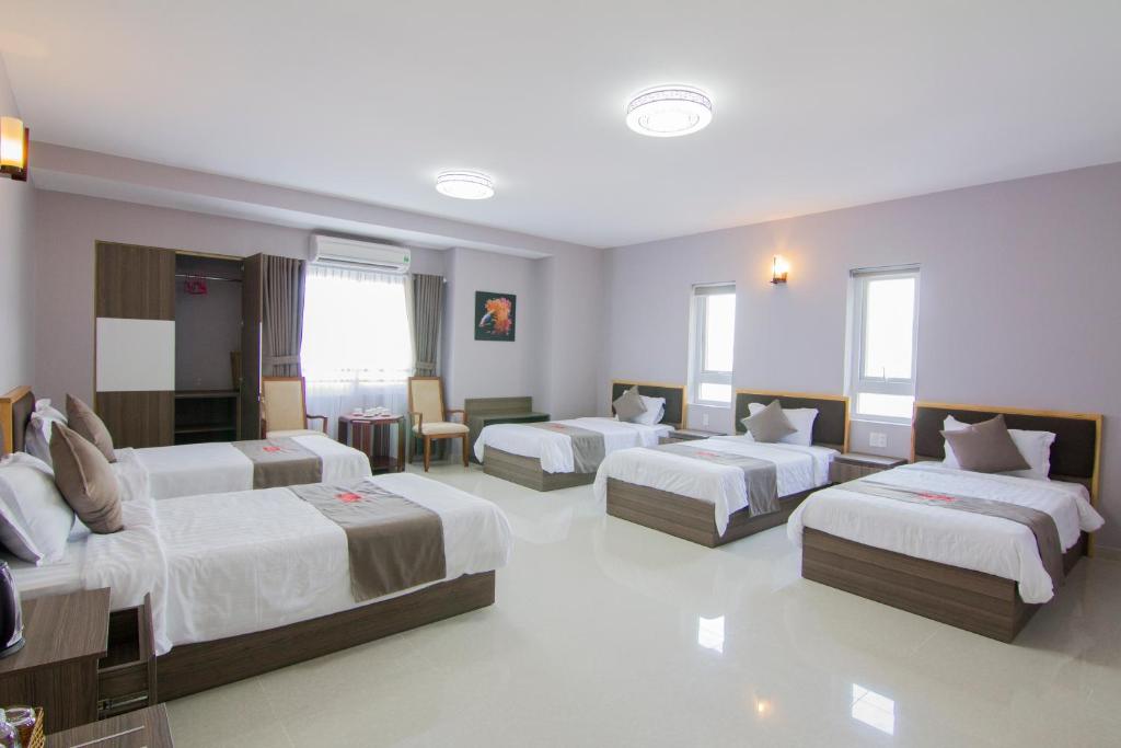 a hotel room with three beds in a room at Khách sạn San Hô Vũng Tàu (Coral Hotel) in Vung Tau