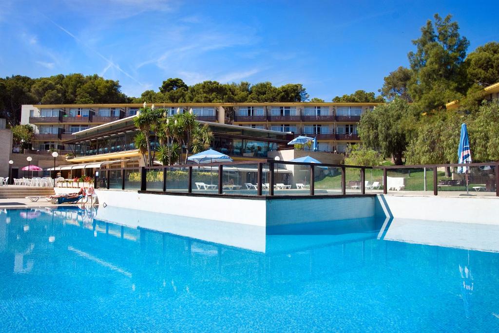une grande piscine en face d'un hôtel dans l'établissement Aparthotel Comtat Sant Jordi, à Platja d'Aro