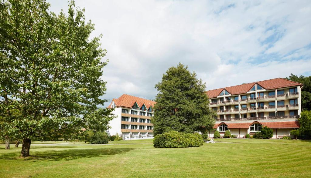 een groot gebouw met bomen ervoor bij Waldhotel Bärenstein in Horn-Bad Meinberg