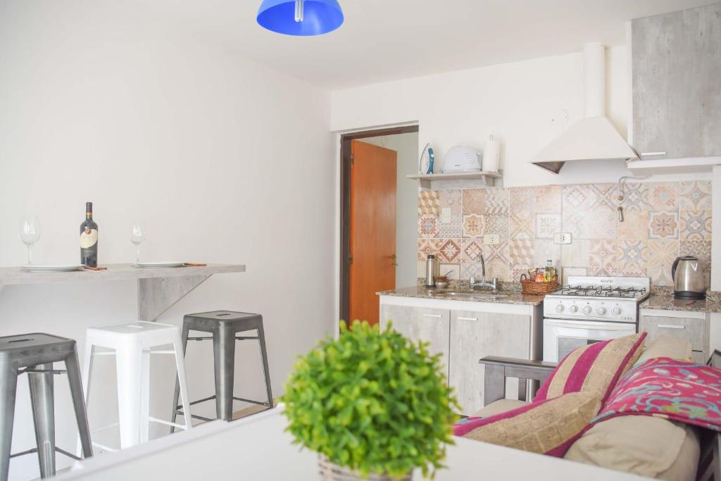 una cucina con tavolo e alcuni sgabelli in una stanza di Apartamentos quinta sección a Mendoza