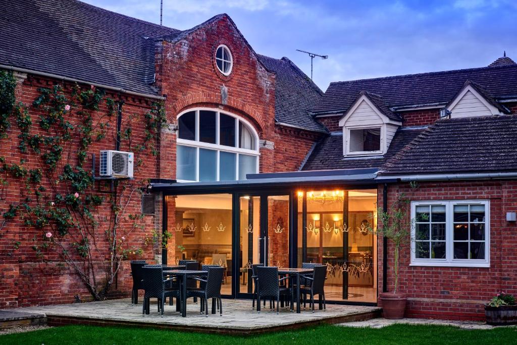 an extension to a brick house with tables and chairs at Kings Court Hotel in Alcester
