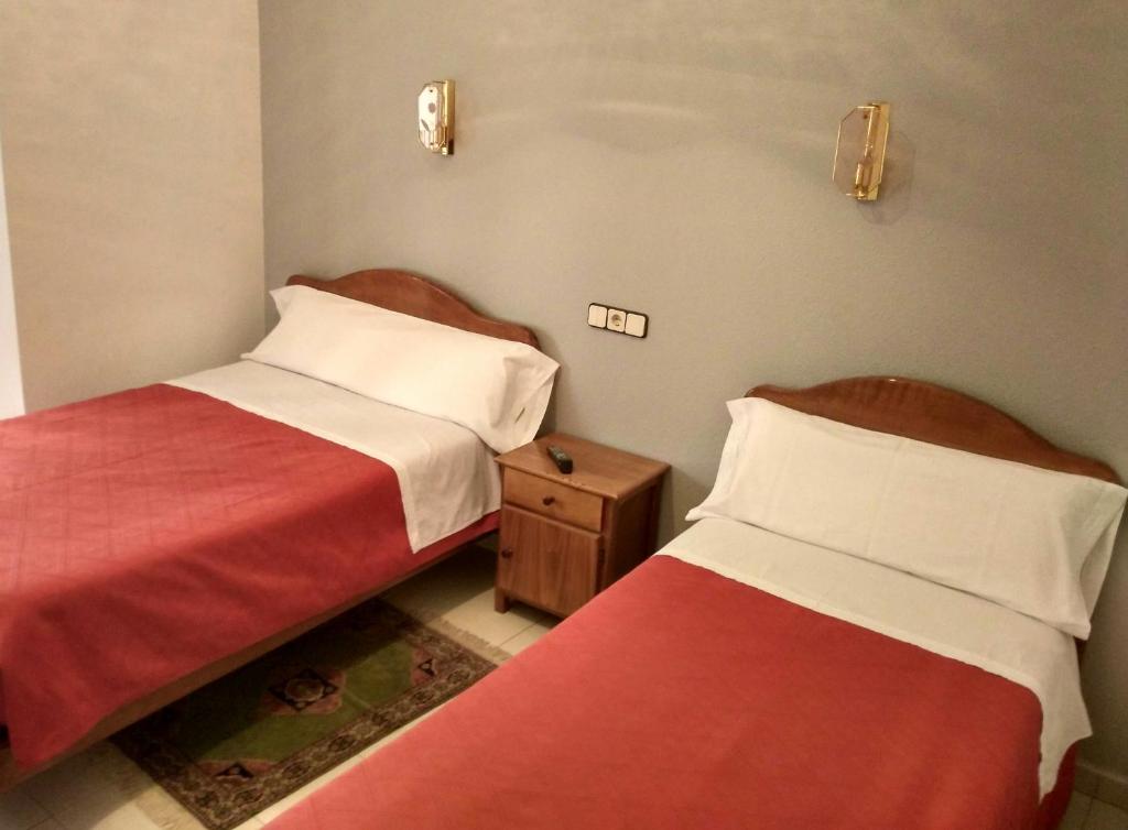 - deux lits assis l'un à côté de l'autre dans une pièce dans l'établissement Hostal Gaudí, à Madrid