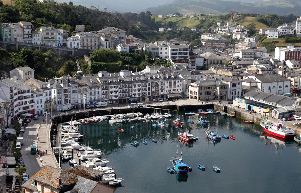 un grupo de barcos en un puerto en una ciudad en Hotel Baltico, en Luarca