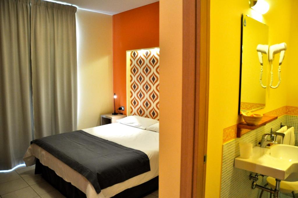Habitación de hotel con cama y lavabo en Letto & Riletto, en Montecassiano
