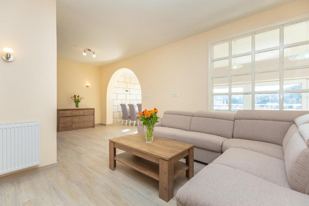 uma sala de estar com um sofá e uma mesa com flores em Finnella em Dubrovnik