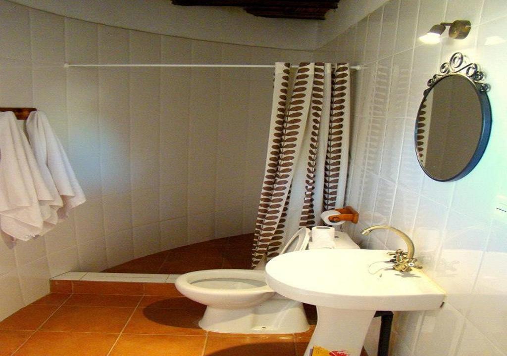a bathroom with a toilet and a sink at Le Petit Quartier "Chez Amanthia" in Cap Skirring