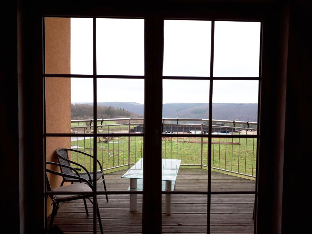 Blick auf einen Tisch und Stühle aus dem Fenster in der Unterkunft Ferienwohnung Farrenkopf in Hambrunn