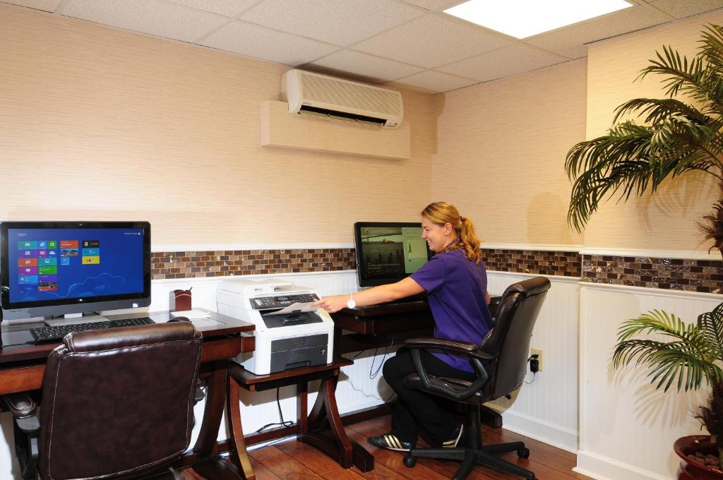 a woman sitting at a desk in front of a computer at Holiday Pavilion Resort on the Boardwalk in Myrtle Beach
