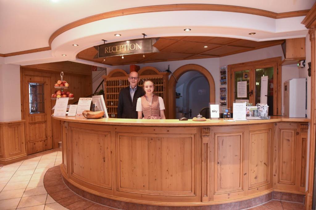 a man and woman standing at a bar in a restaurant at Hotel & Gasthof Richard Held in Regensburg