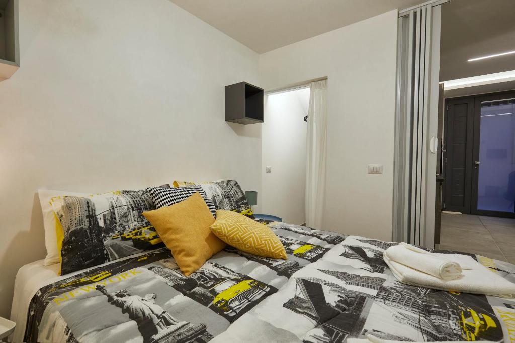 łóżko z czarno-białą kołdrą i żółtymi poduszkami w obiekcie Annetta home w mieście Scicli