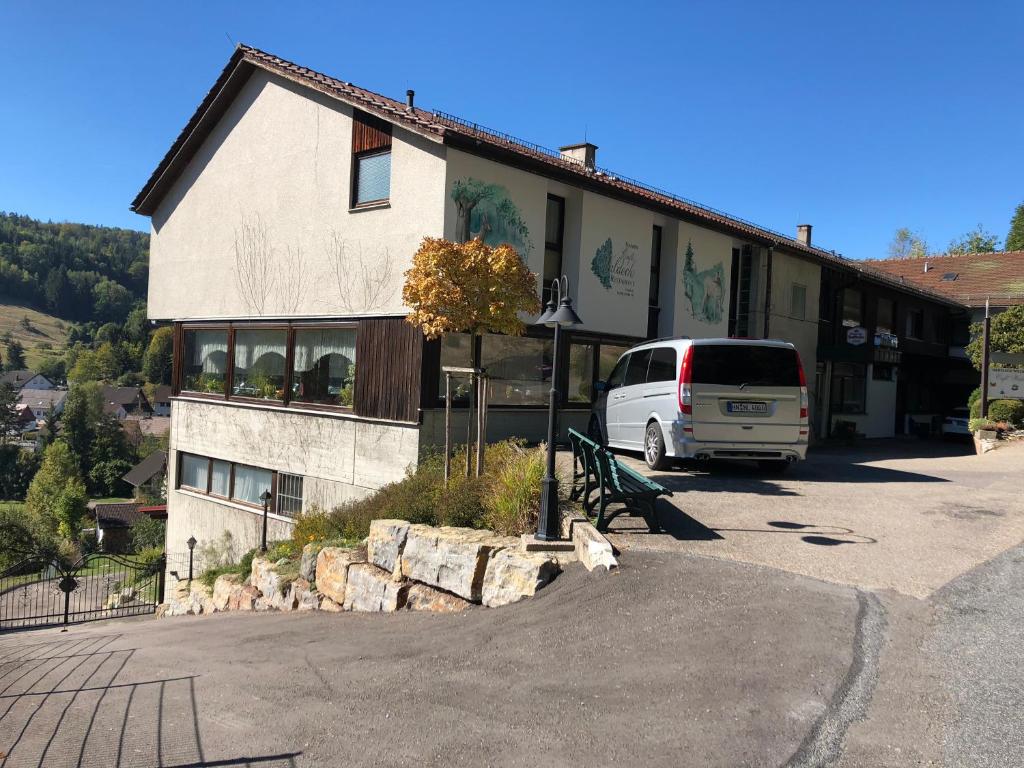 une camionnette blanche garée devant un bâtiment dans l'établissement Hotel Cafe Waldeck, à Wüstenrot