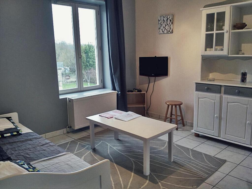 een woonkamer met een tafel en een keuken bij Gîtes de Loire in Mosnes