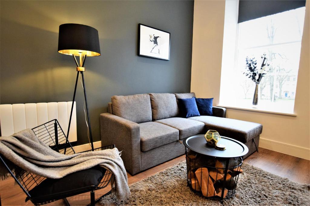 ein Wohnzimmer mit einem Sofa und einem Tisch in der Unterkunft The Hubert - Your Apartment in Bristol