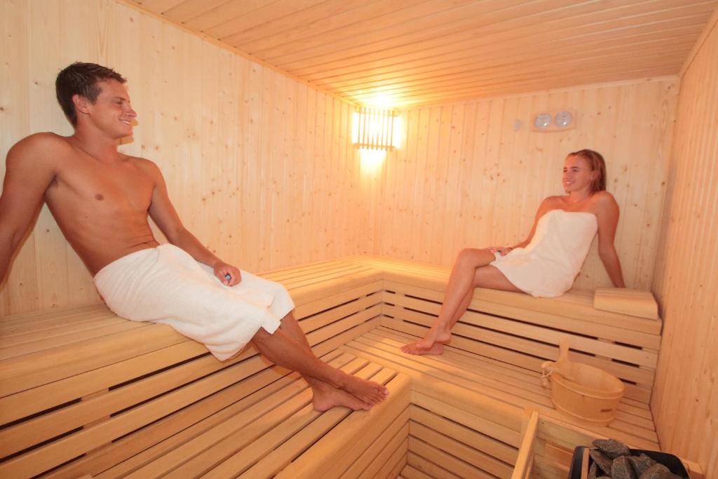 a man and a woman sitting in a sauna at HL Suitehotel Playa del Inglés - Adults Only in Playa del Ingles