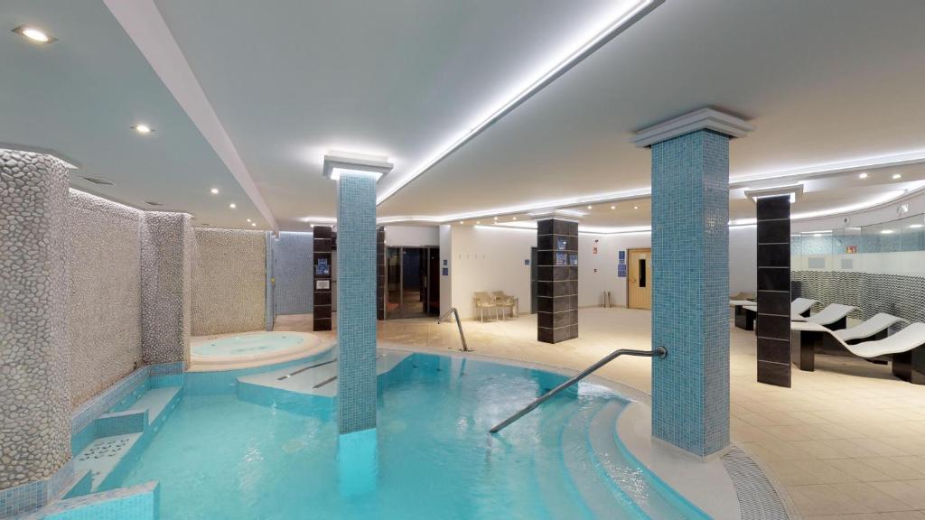 a large swimming pool in a hotel with columns at HL Suitehotel Playa del Inglés - Adults Only in Playa del Ingles