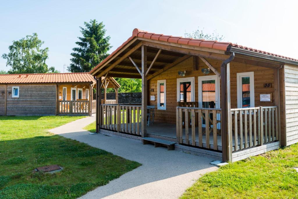 a wooden cabin with a porch in a park at Chateau De La Plinguetiere in Saint-Aignan-Grand-Lieu