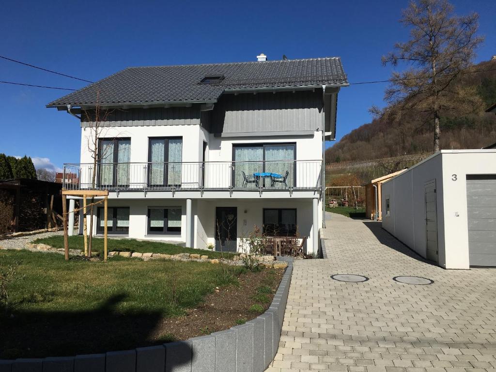 a white house with a black roof at Ferienwohnung Gluiber in Beuren