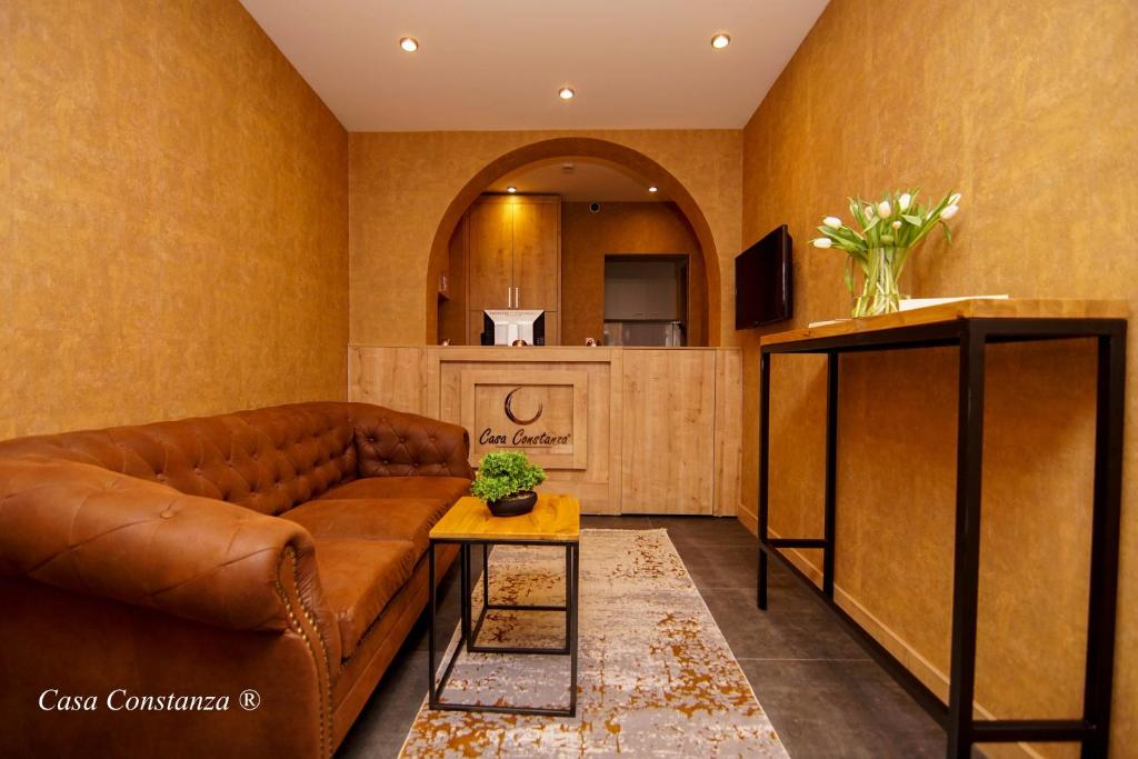 a living room with a brown couch and a table at Casa Constanza Hotel Garni in Friedrichshafen