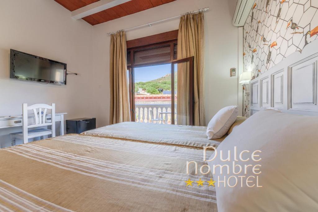 a bedroom with a large bed and a balcony at Dulce Nombre Hotel - Apartamentos in Tarifa
