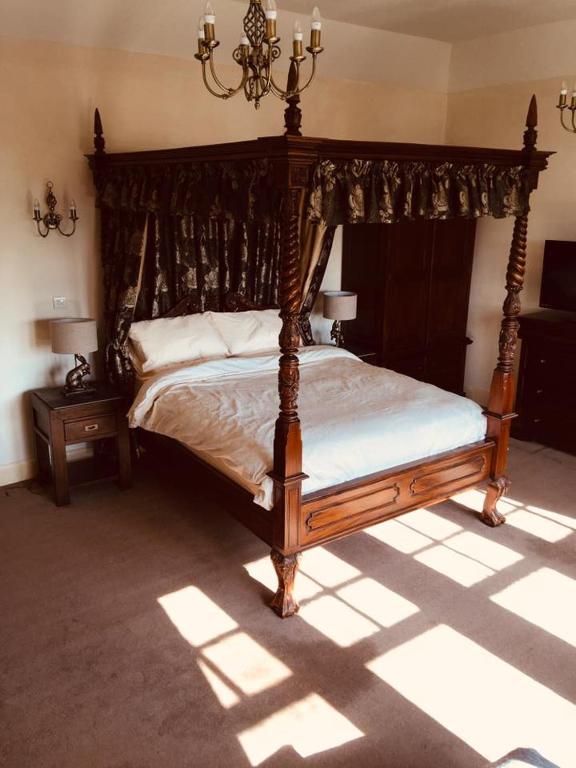 a bedroom with a wooden bed with a canopy at Brass Castle Country House Accommodation in Middlesbrough