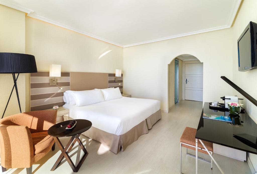 a hotel room with a bed and a desk and a tv at H10 Gran Tinerfe - Adults Only in Adeje