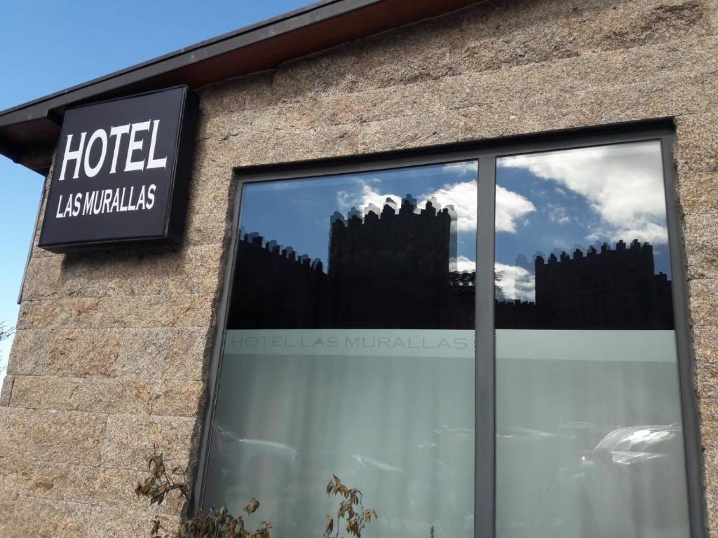 a building with a reflection of a castle in a window at Hotel Las Murallas in Avila