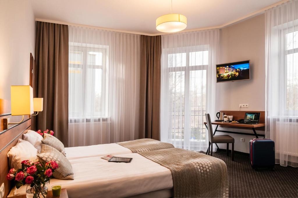 um quarto de hotel com uma cama e uma secretária em Hotel Wilga na Cracóvia
