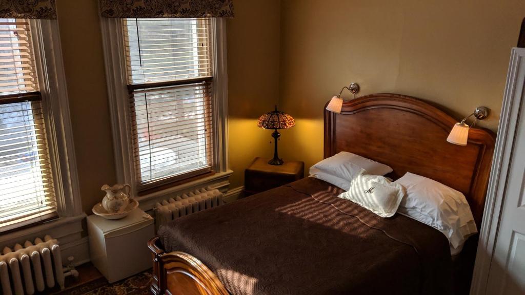 a bedroom with a bed and two windows at McGee's Inn in Ottawa