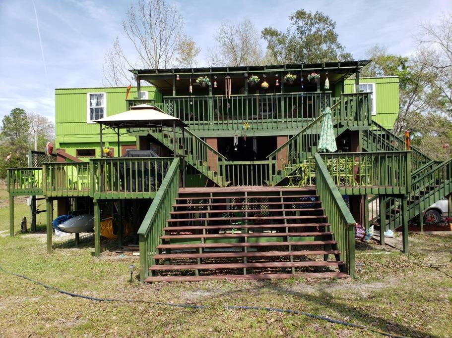 een groot groen huis met een groot terras bij MARGARITAVILLE ON THE SUWANNEE RIVER in Mayo