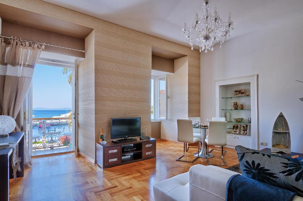 uma sala de estar com televisão e uma mesa com cadeiras em Riva Apartments em Split