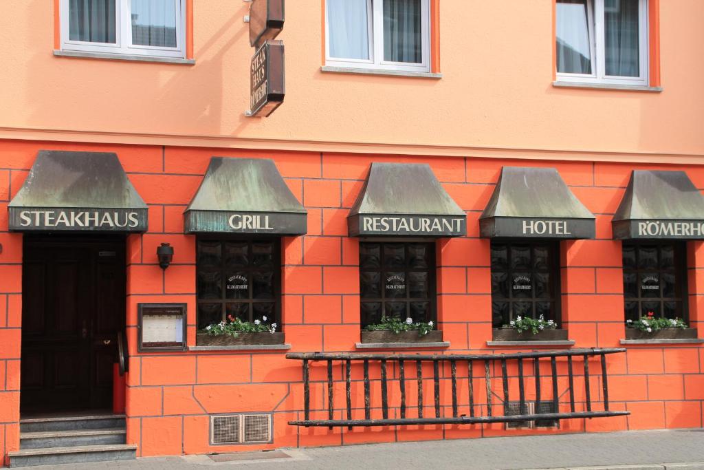 a red brick building with three windows with plants at Hotel Römerhof Hanau by Trip Inn in Hanau am Main