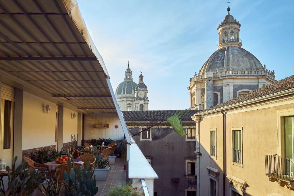 un balcón con mesas y sillas y un edificio en Casa Provenza, en Catania