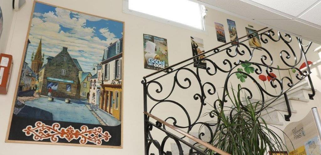 a wall with a painting of a city on it at Hotel Du Cheval Blanc in Saint-Pol-de-Léon