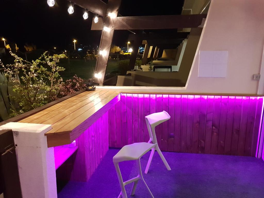 a bar with purple lighting on a patio at night at Studio Naturiste P.Nature 6 in Cap d&#39;Agde