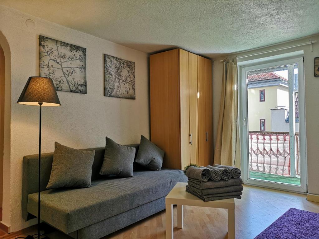 a living room with a couch and a window at Sankt-Nikolaus City Studio in Innsbruck