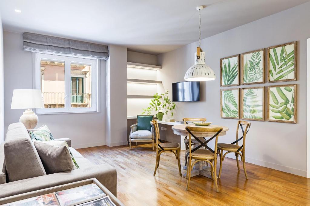a living room with a couch and a table and chairs at Ferrini Home - Etnea Collection in Catania