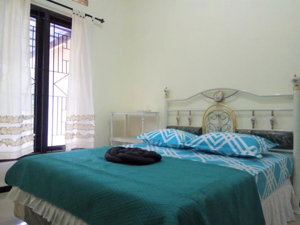 1 dormitorio con 1 cama con colcha azul en Bukir Five, en Malang
