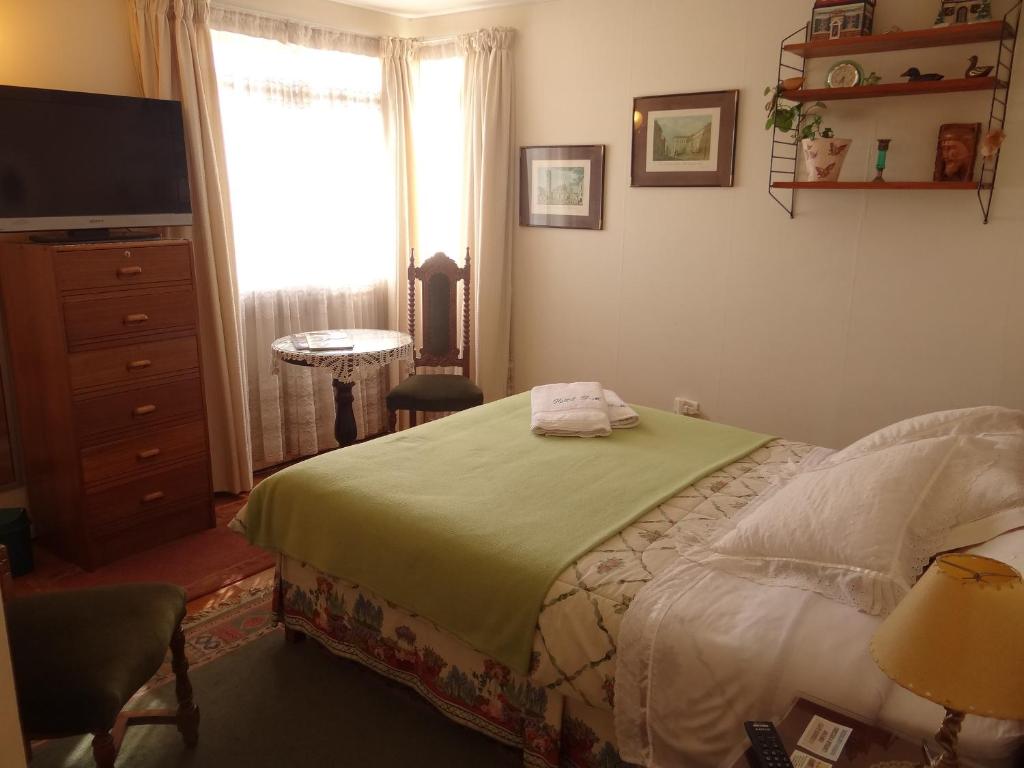 1 dormitorio con 1 cama, TV y ventana en Hostal Don Mariano, en Concepción