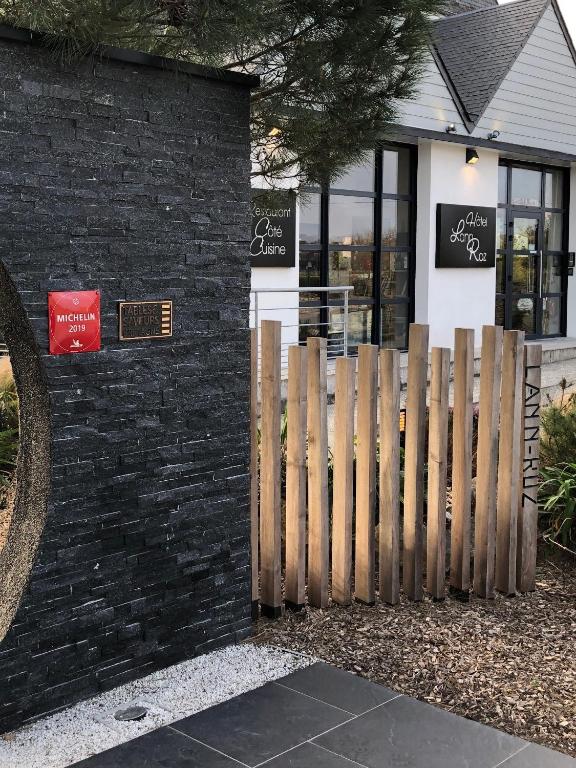 a store with a wooden fence in front of a building at Hotel-Restaurant Lann Roz / Côte Cuisine in Carnac