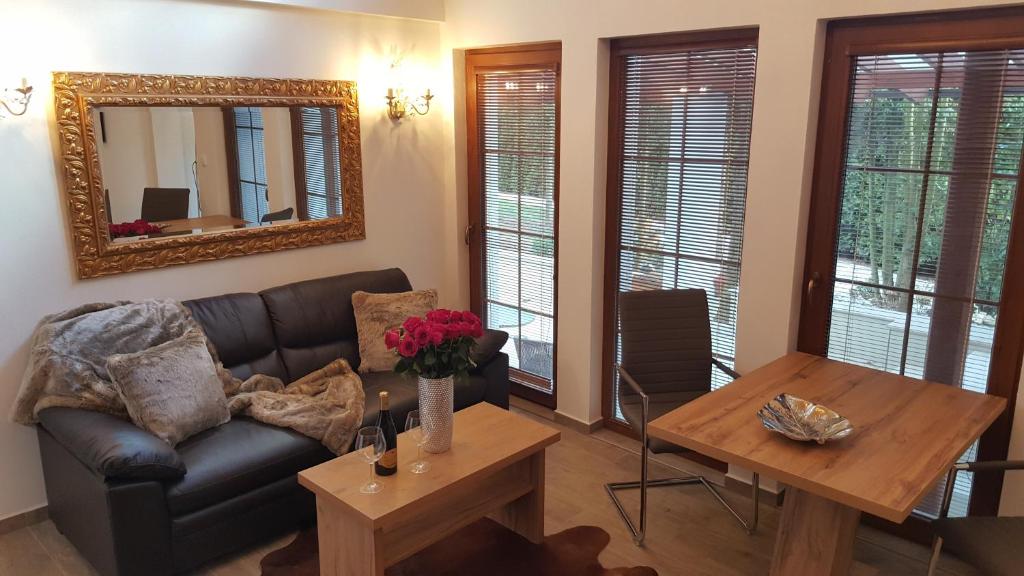 - un salon avec un canapé, une table et un miroir dans l'établissement Village Romantic Apartment by Český Krumlov - adults only, à Střížov
