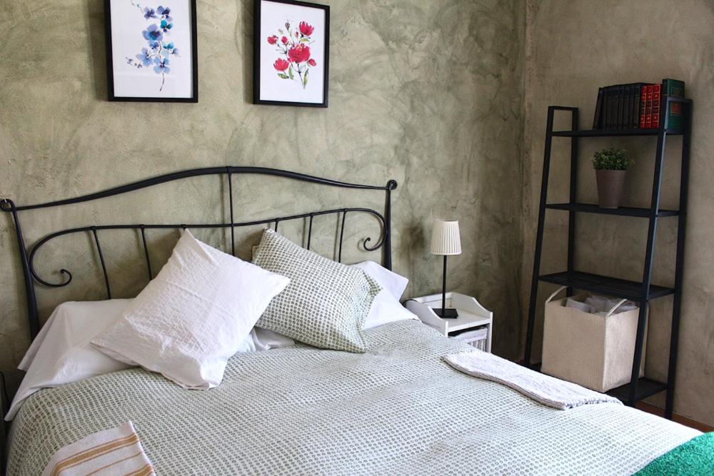 um quarto com uma cama com lençóis brancos e almofadas em Casa del Plantel em La Granja de San Ildefonso