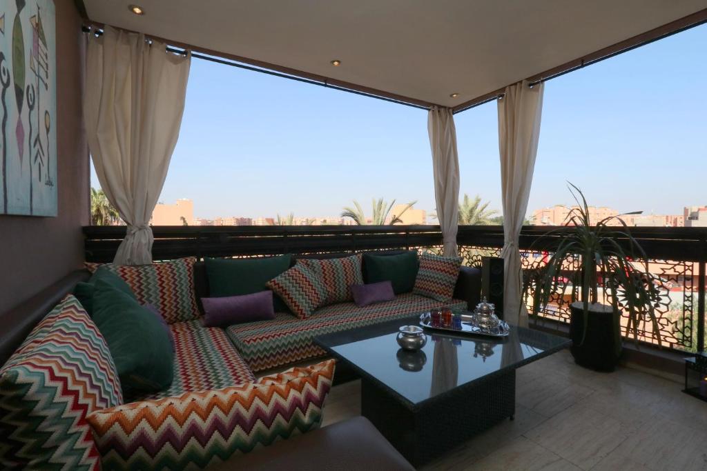 Sweet Jacob's Appartment Gueliz City Center في مراكش: غرفة معيشة مع أريكة وطاولة على شرفة