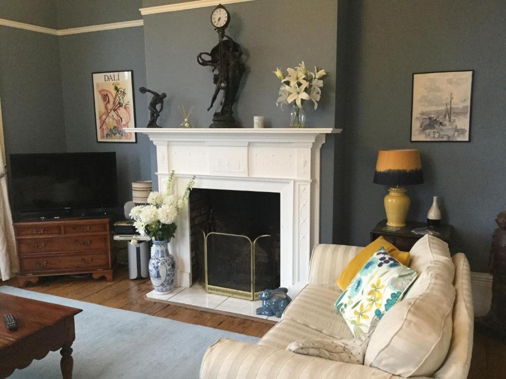 a living room with a couch and a fireplace at Glebe House in Deal