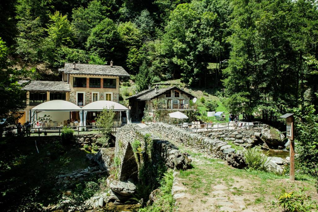 a house with a stone wall next to a river at Mulìn Turcìn in Coassolo Torinese