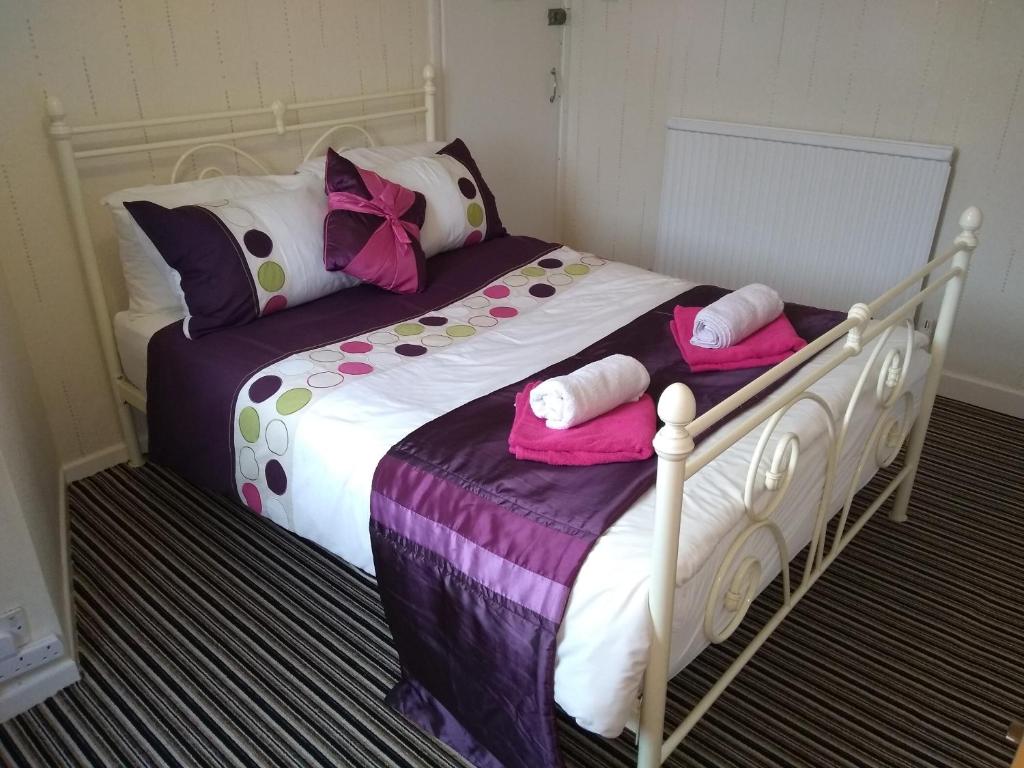 a bedroom with a bed with pink towels on it at Diamond House in Great Yarmouth