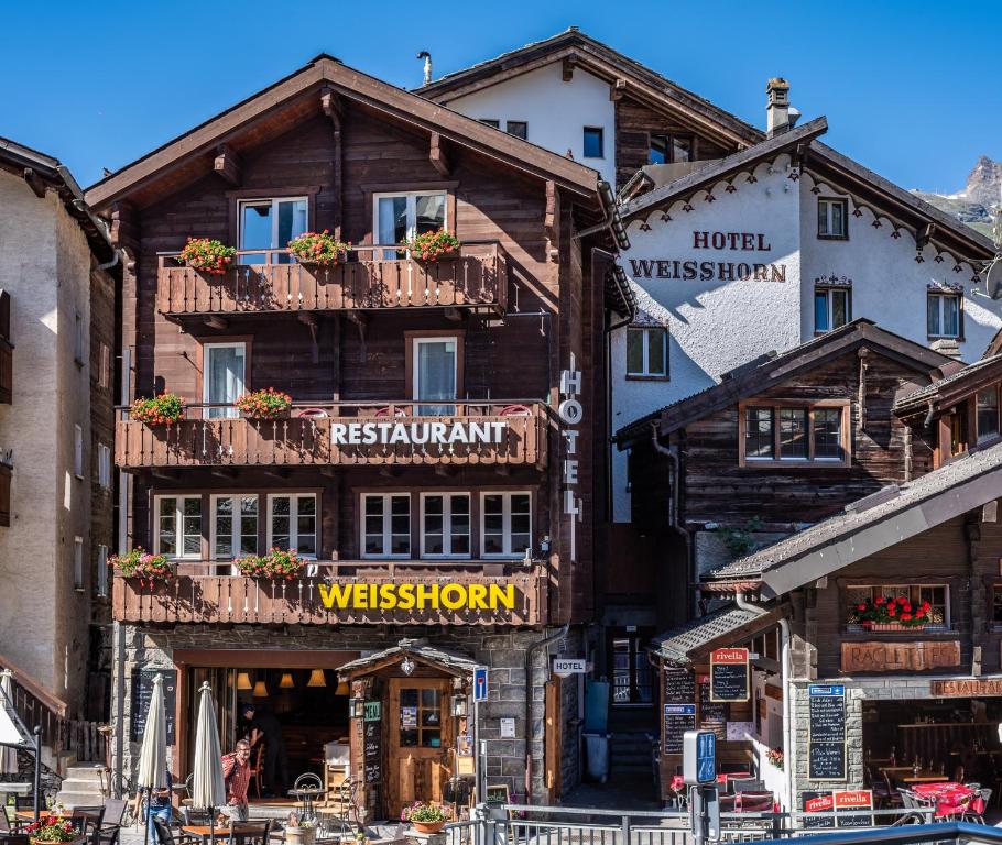 a wooden building with a sign in front of it at Hotel Weisshorn in Zermatt